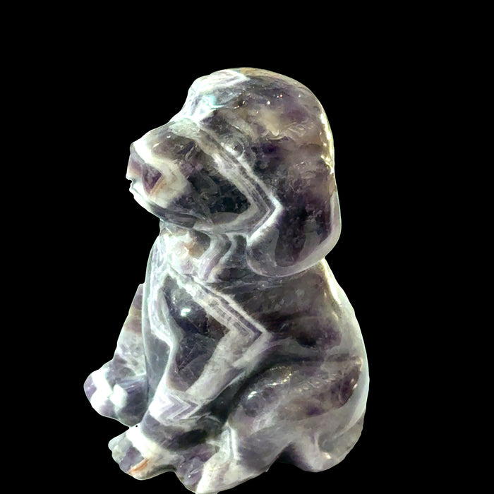 Amethyst Trapiche Gemstone Carved Dog on a black background, right side view.