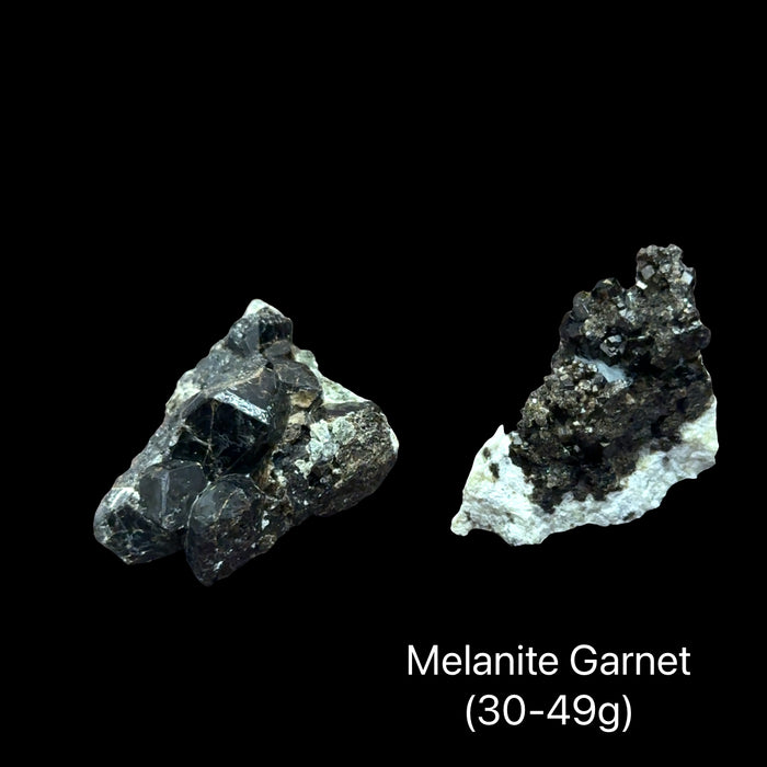 Two Raw black garnet crystal cluster in natural matrix (30-49g) for root chakra grounding psychic protection and courage with earth and fire energy on a black background, front view.