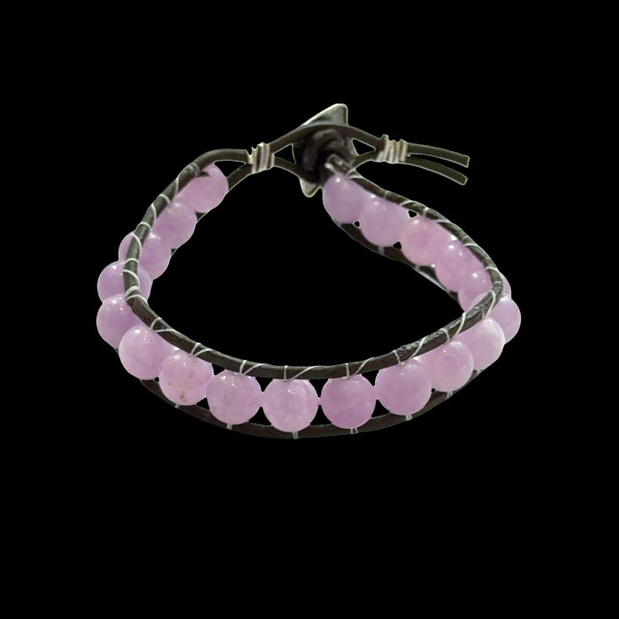 Close-up of genuine Lavender Jade beads showing soft purple and lavender hues, 8mm gemstone bracelet for emotional healing, on a black background, front view.