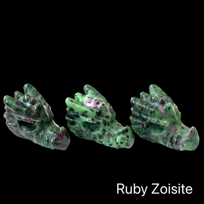 Three Ruby Zoisite gemstone Dragon Heads on a black background, right-angle front view.