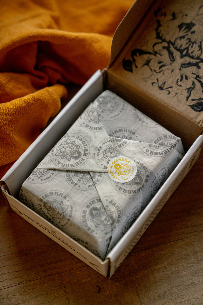 Packaged product in a box with a decorative label on a wooden surface