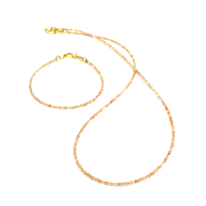 Close-up of faceted sunstone gemstone beads on delicate beaded bracelet with natural shimmer and gold-filled clasp on a white background with its matching necklace, front view.