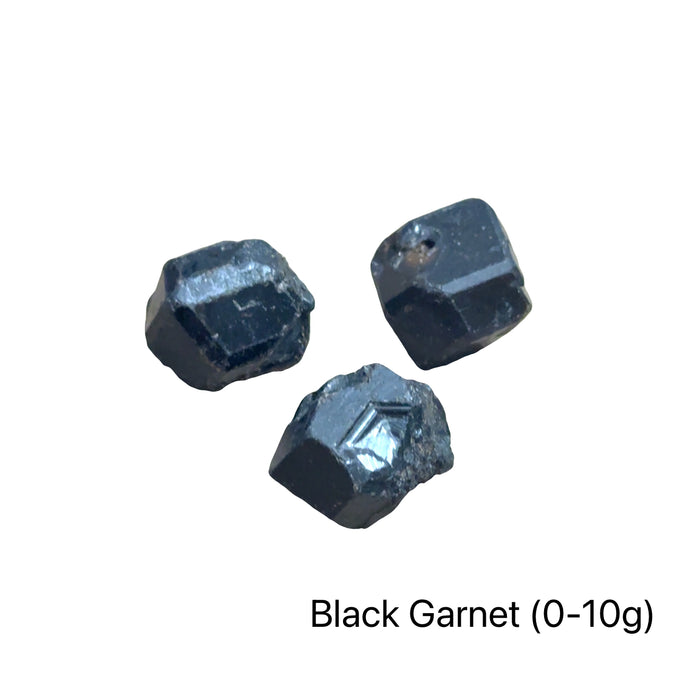 Three Raw black garnet crystal clusters. Black garnet raw specimen without matrix showing dodecahedral crystal formation for strength, resilience, and energetic protection on a white background, front view (0-10g).