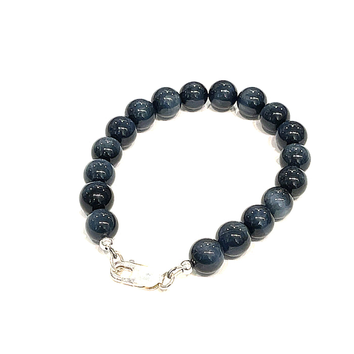 8.5mm Blue Tiger Eye gemstone beaded bracelet with sterling silver lobster claw clasp showing deep midnight blue chatoyant bands on a white background, left angle back view.