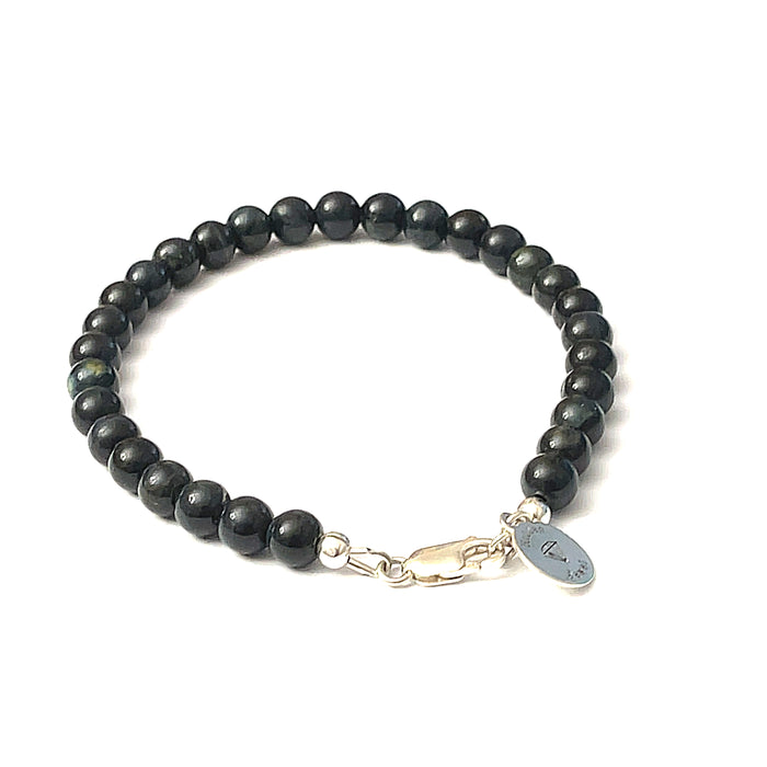 6mm Blue Tiger Eye gemstone beaded bracelet with sterling silver lobster claw clasp showing deep midnight blue chatoyant bands on a white background, back view.