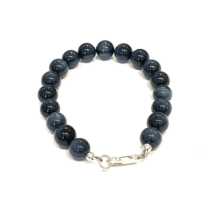 8.5mm Blue Tiger Eye gemstone beaded bracelet with sterling silver lobster claw clasp showing deep midnight blue chatoyant bands on a white background, back view.
