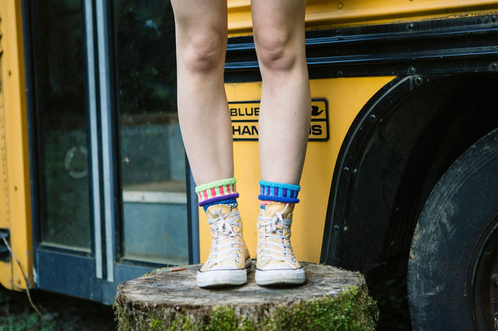 Bluebell Crew Socks worn with trainers beside a school bus outdoors