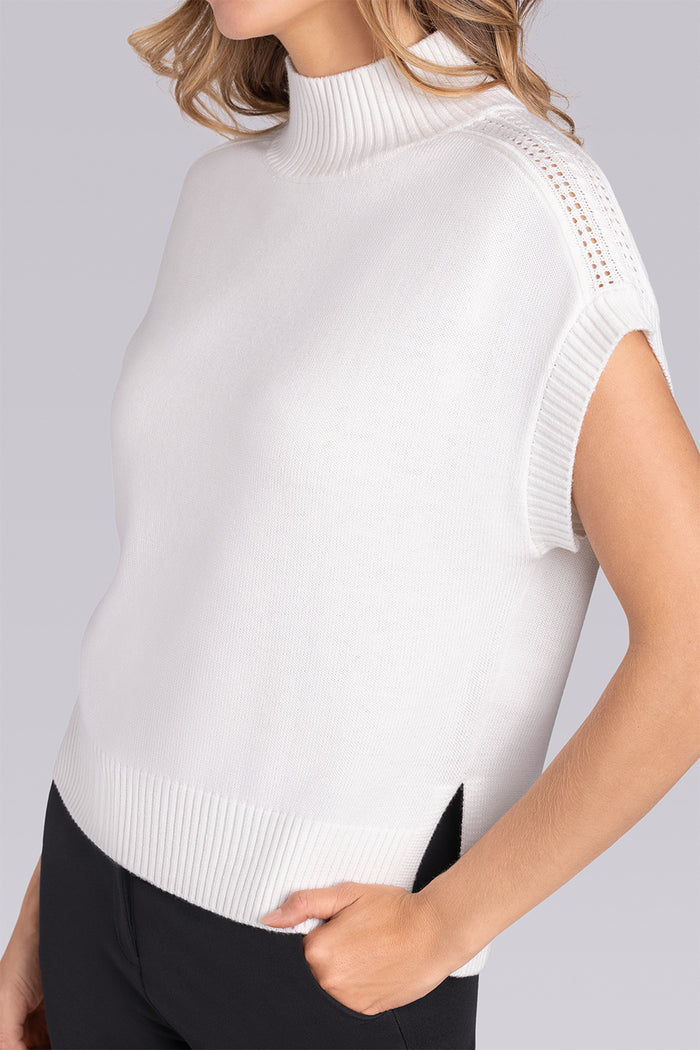 Model wearing the Charisma Off White short sleeve knit shirt, styled with black pants.