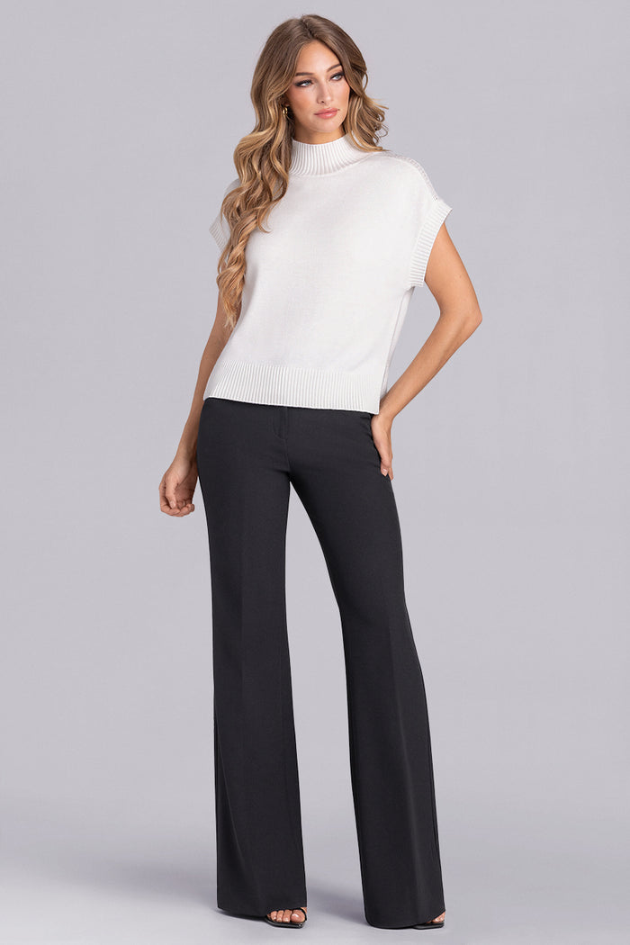 Model wearing the Charisma Off White short sleeve knit shirt, styled with black pants.