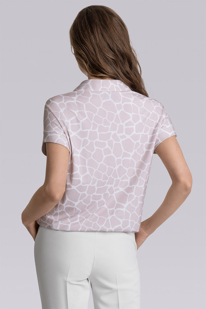 Model wearing the Conquest Sand Icy Bamboo® geo-printed short sleeve notched neck shirt, styled with white pants.