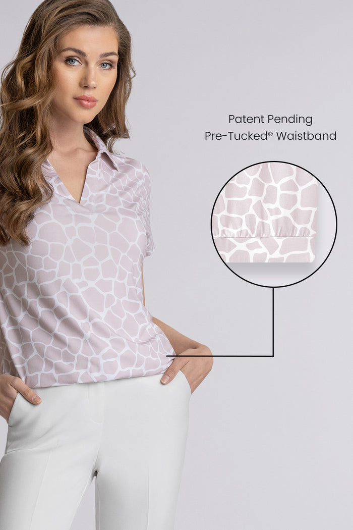 Model wearing the Conquest Sand Icy Bamboo® geo-printed short sleeve notched neck shirt, styled with white pants.
