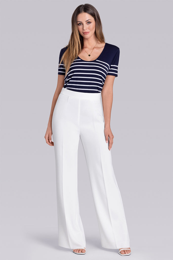 Model wearing the Daydream Deep Sea Blue White scoop neck stripped short sleeve tee, styled with white pants