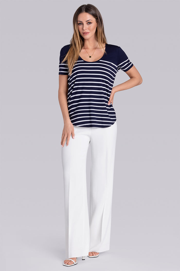 Model wearing the Daydream Deep Sea Blue White scoop neck stripped short sleeve tee, styled with white pants