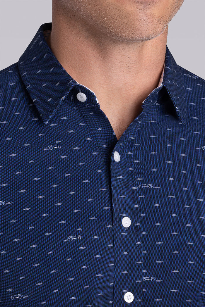 Model wearing Drift Dark Navy short sleeve car print shirt, styled with white shorts