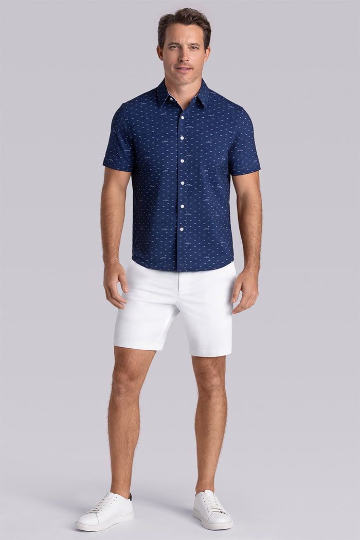 Model wearing Drift Dark Navy short sleeve car print shirt, styled with white shorts