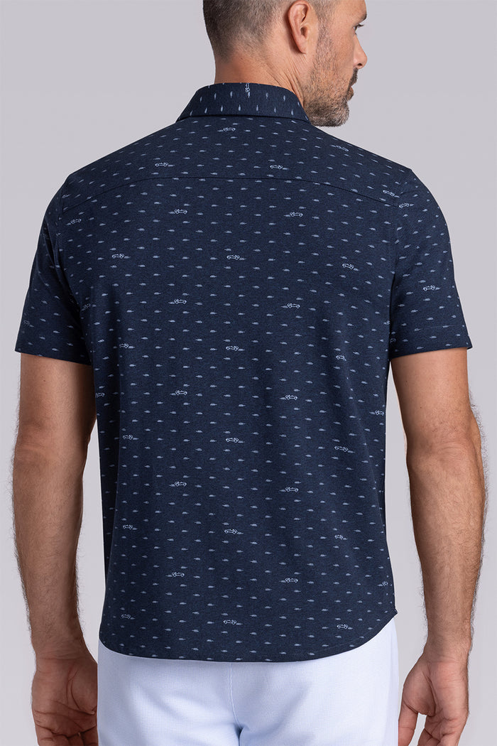 Model wearing Drift Legion Blue Heather short sleeve car print shirt, styled with white shorts
