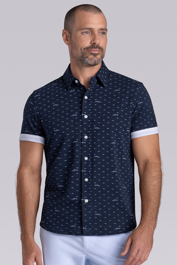 Model wearing Drift Legion Blue Heather short sleeve car print shirt, styled with white shorts