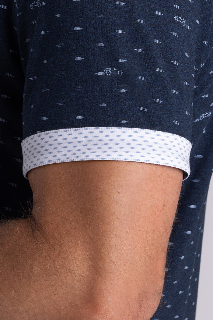 Model wearing Drift Legion Blue Heather short sleeve car print shirt, styled with white shorts
