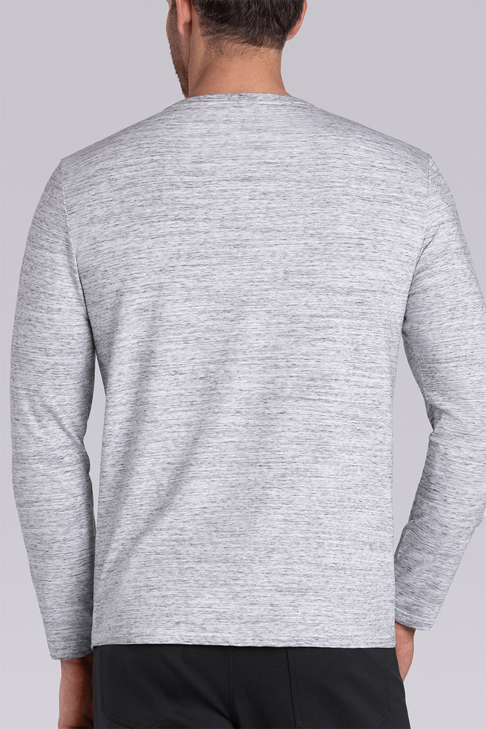 Model wearing Elemental Bone White Heather long sleeve henley shirt, styled with black pants.