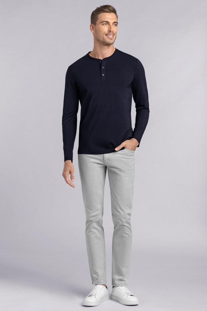 Model wearing Elemental Navy long sleeve henley shirt, styled with black pants.