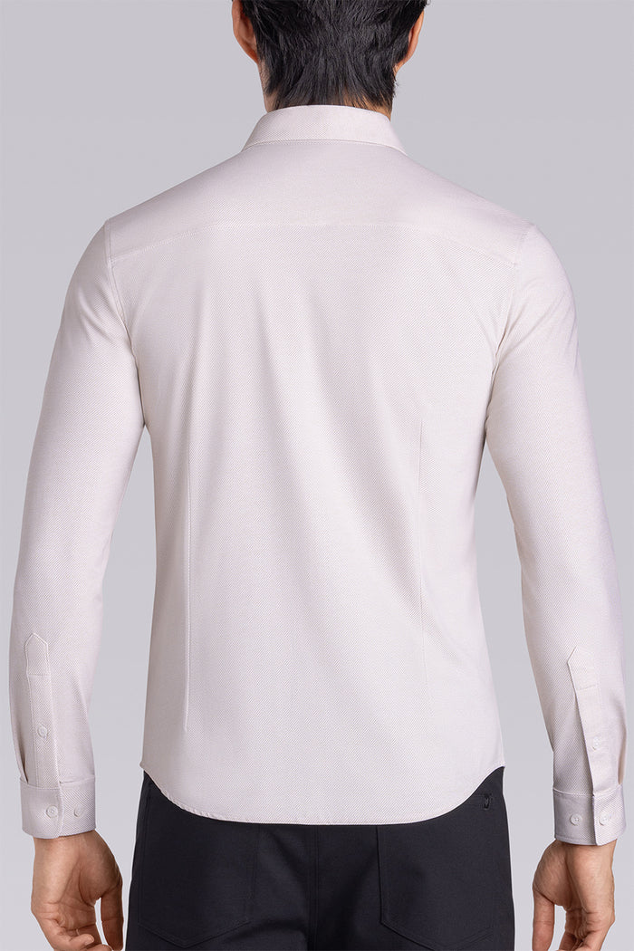 Model wearing the Elusive Champagne long sleeve dress shirt, styled with fitted black dress slacks.