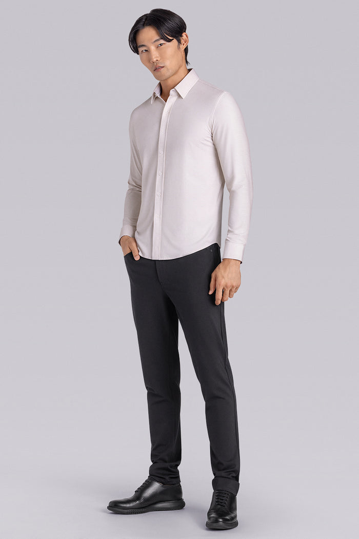 Model wearing the Elusive Champagne long sleeve dress shirt, styled with fitted black dress slacks.
