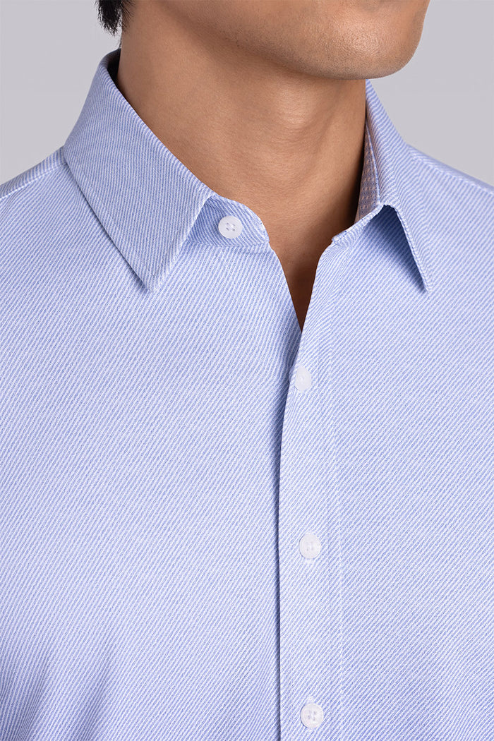 Model wearing the Elusive Light Blue long sleeve dress shirt, styled with fitted black dress slacks.