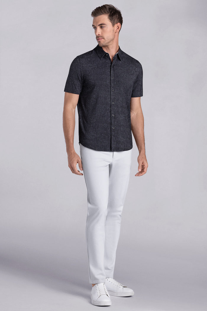 Model wearing Eminent Black short sleeve print shirt, styled with white pants.