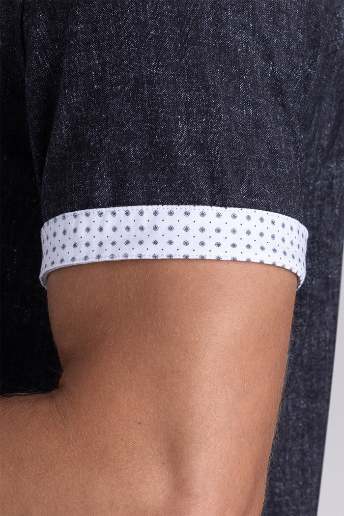 Model wearing Eminent Black short sleeve print shirt, styled with white pants.