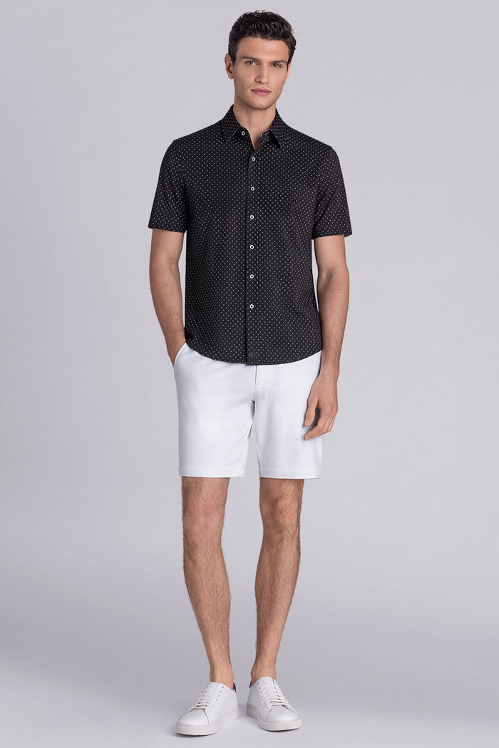 Model wearing Exhilarate Black short sleeve shirt, styled with white shorts