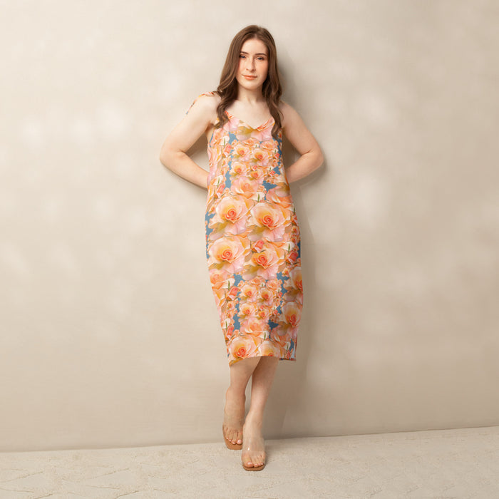 Model wearing a boho streetwear style midi dress with side slit in the Apricot Bloom botanical print for spring fashion 2026 collection.