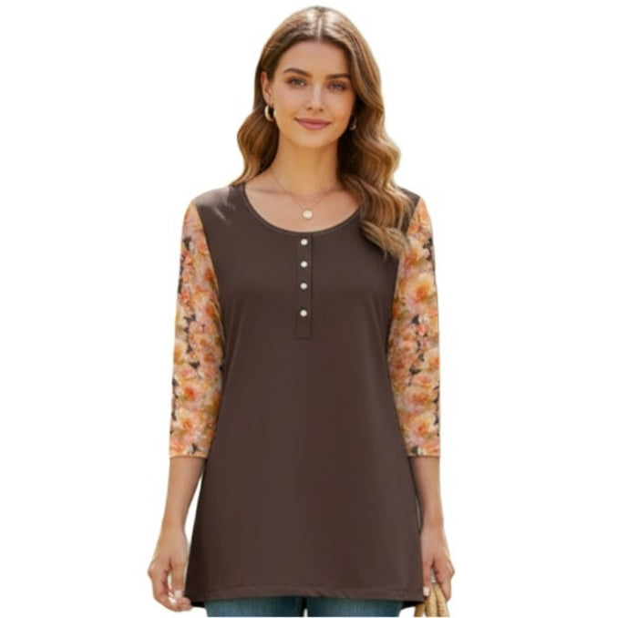 A front view of a woman smiling, wearing a mixed-media tunic top. The body of the shirt is a solid chocolate brown with a round neckline and a vertical row of four white buttons. The three-quarter length sleeves feature the same peach-colored rose floral print seen on the back of the garment.