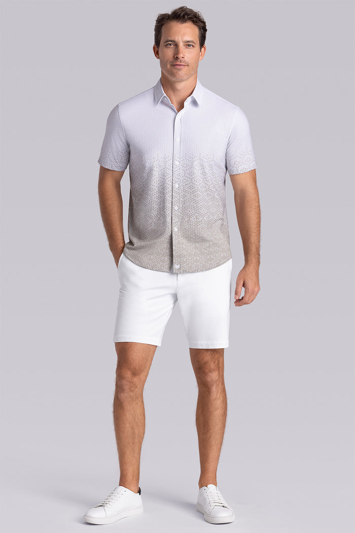Model wearing Flow Light Sage Cotton® short sleeve ombre print shirt, styled with white shorts