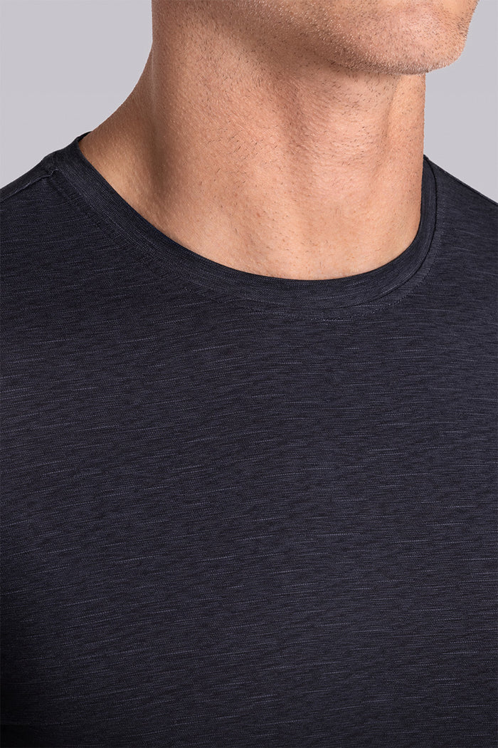 Model wearing Fundamental Black Charcoal Icy Bamboo® short sleeve crewneck, styled with white pants.