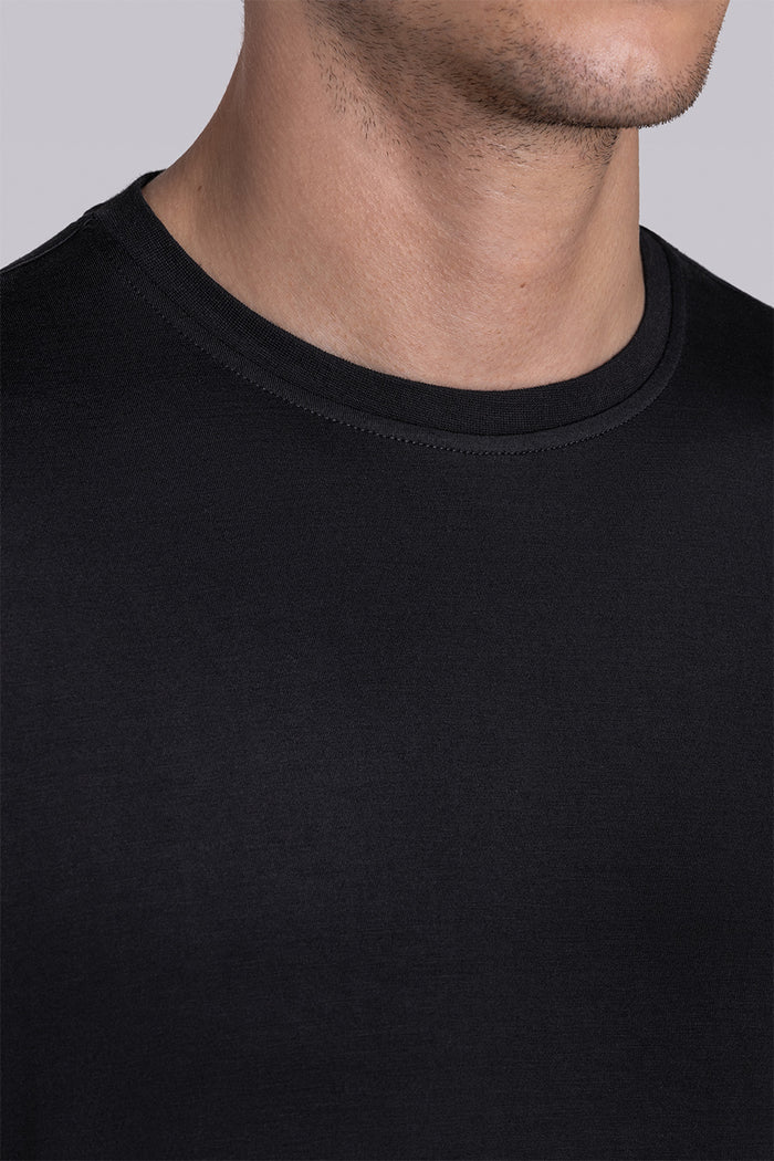 Model wearing Fundamental Black Icy Bamboo® short sleeve crewneck, styled with white shorts.