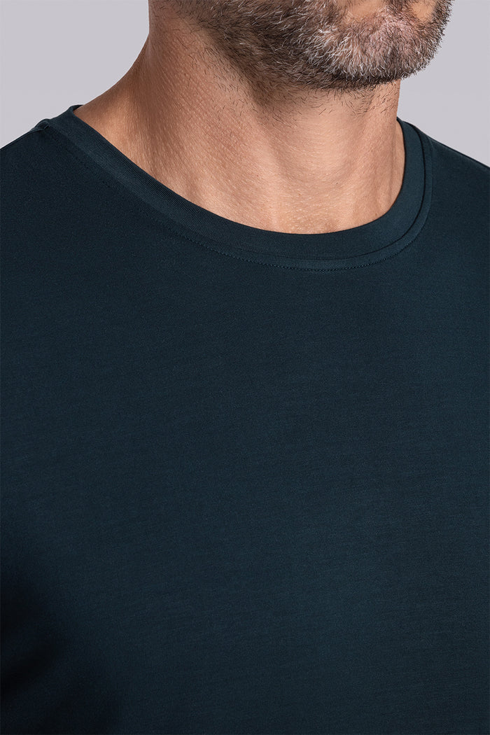 Model wearing Fundamental Black Charcoal Icy Bamboo® short sleeve crewneck, styled with white pants.