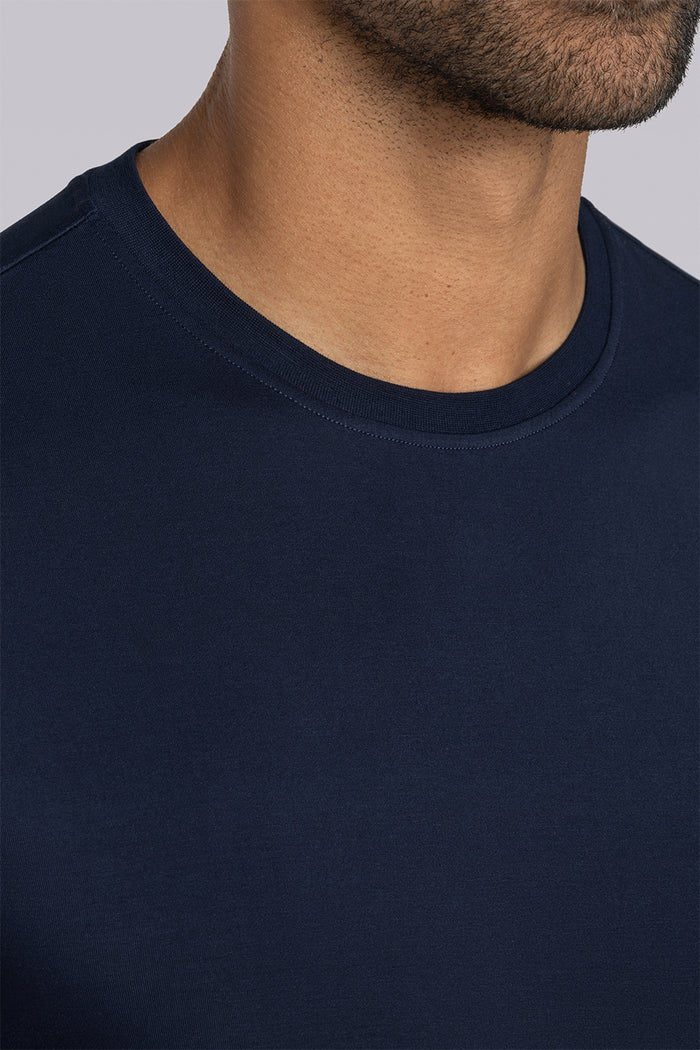 Model wearing Fundamental Monaco Blue Icy Bamboo® short sleeve crewneck, styled with white pants.
