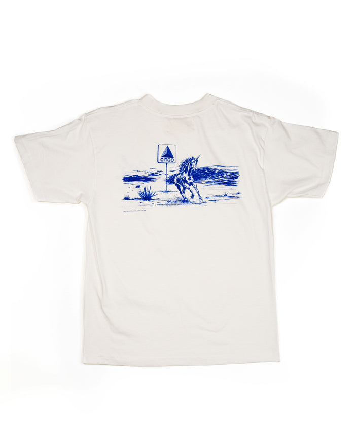 White t-shirt with blue graphic of a unicorn and landscape on a white background