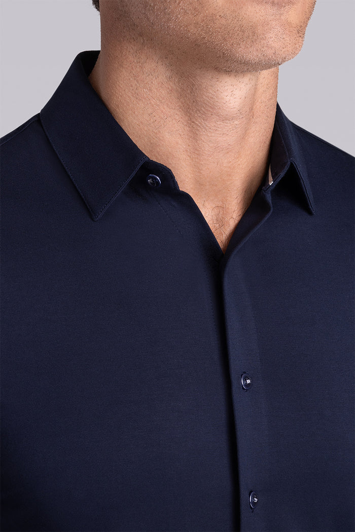Model wearing Illustrious Monaco Blue Icy Bamboo® long sleeve dress shirt, styled with white pants