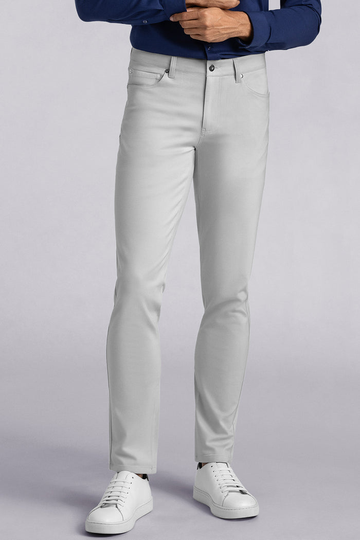 Model wearing Kinetic Light Grey dress slacks pants, styled with comfortable navy shirt