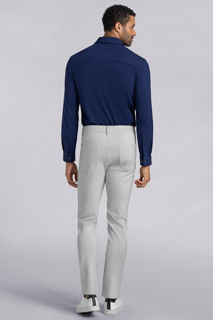 Model wearing Kinetic Light Grey dress slacks pants, styled with comfortable navy shirt