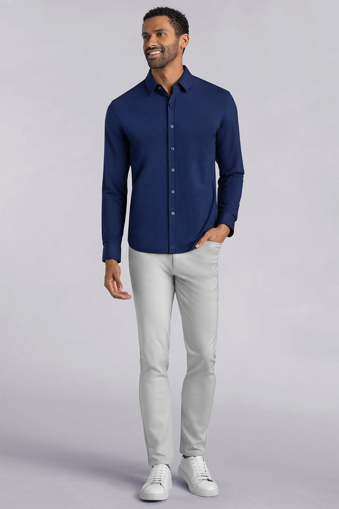 Model wearing Kinetic Light Grey dress slacks pants, styled with comfortable navy shirt