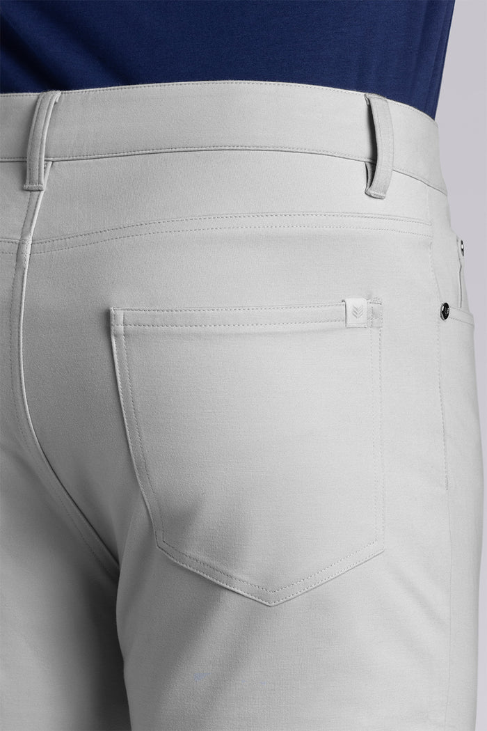 Model wearing Kinetic Light Grey dress slacks pants, styled with comfortable navy shirt
