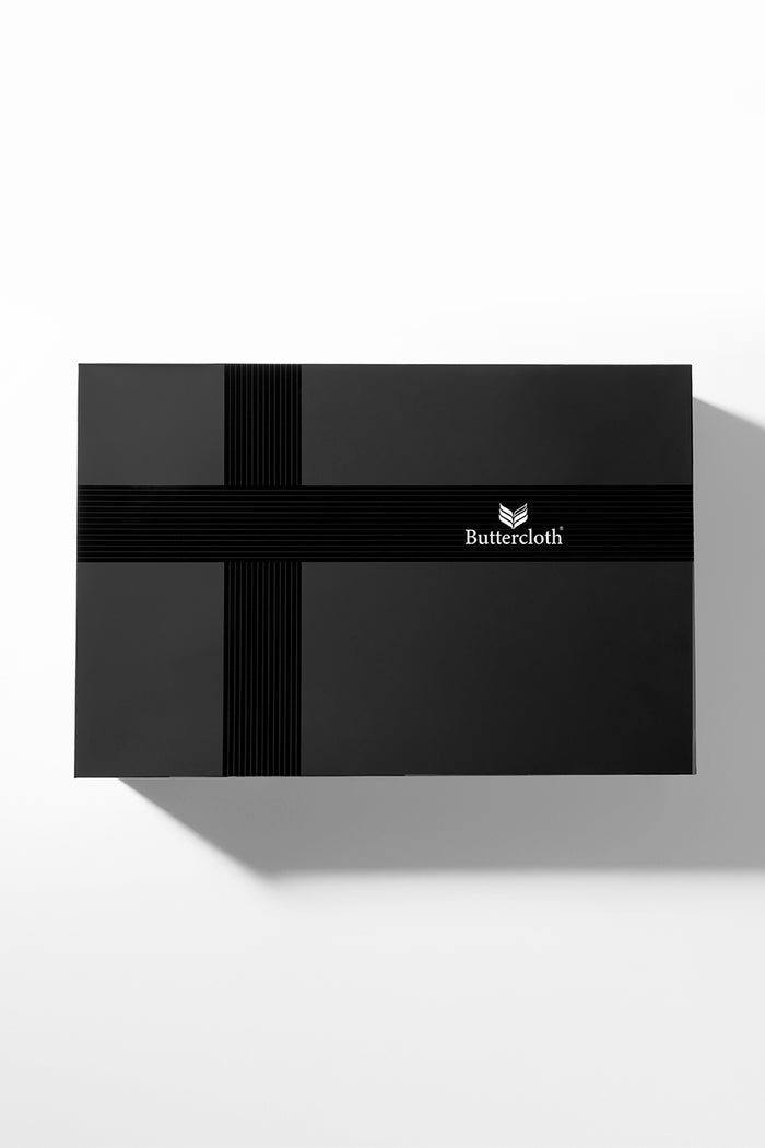 A black luxurious gift box with a black ribbon tied around it.