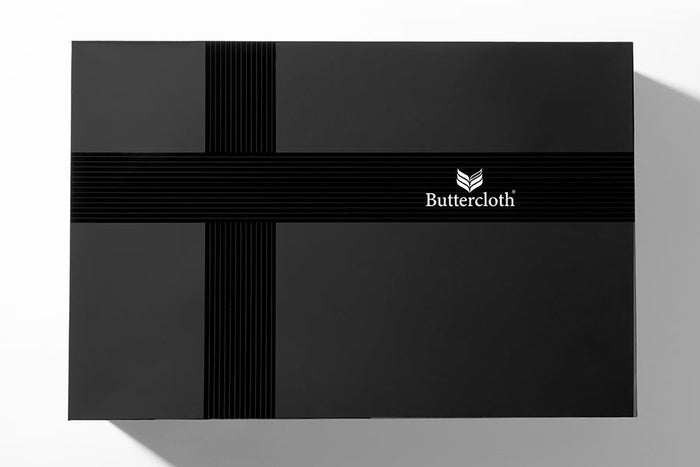 A black luxurious gift box with a black ribbon tied around it.