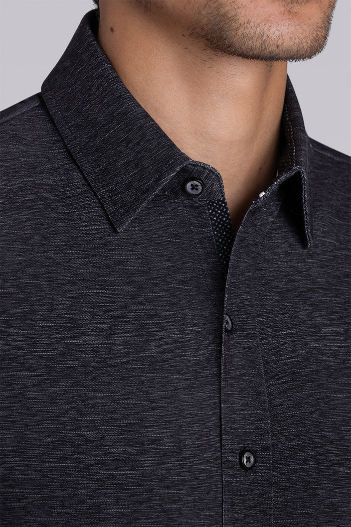 Model wearing Magnetic Black short sleeve collar shirt, styled with white pants.