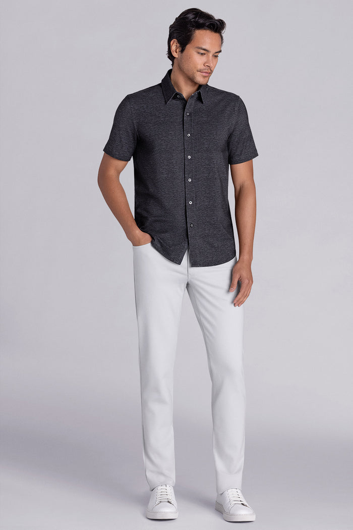 Model wearing Magnetic Black short sleeve collar shirt, styled with white pants.