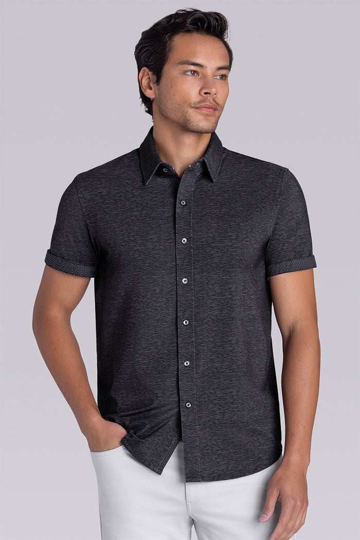 Model wearing Magnetic Black short sleeve collar shirt, styled with white pants.