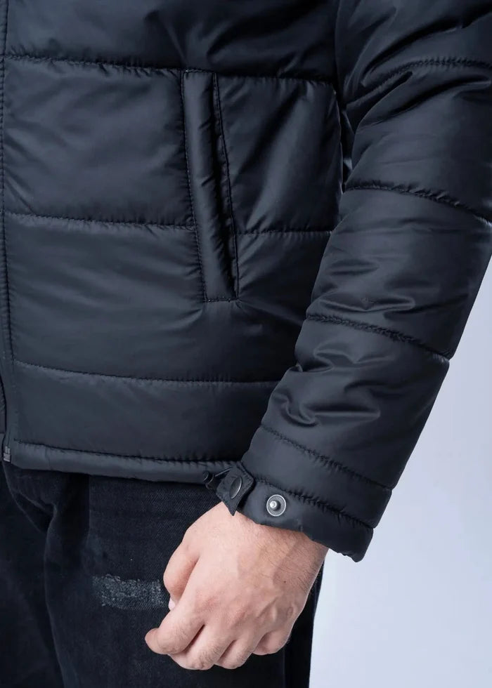 Men's black quilted jacket cuff with snap button and stitched pocket detail