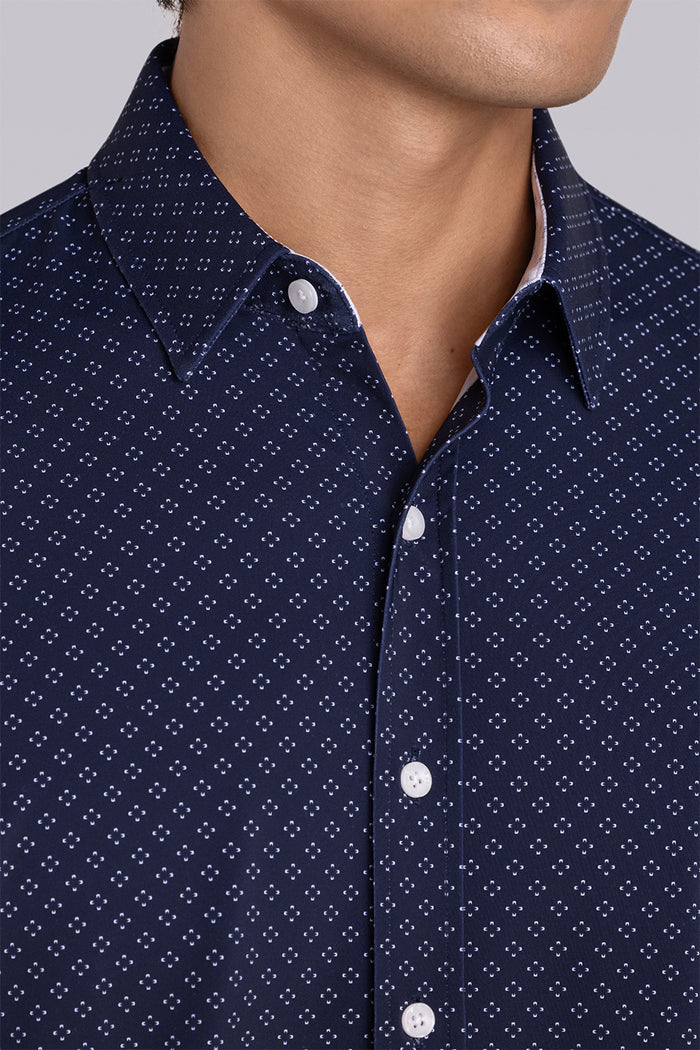 Model wearing Mesmerize Navy long sleeve dress shirt, styled with grey pants.